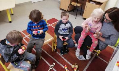 Na zdjęciu Pani Agnieszka ze swoim oddziałem. Dzieci siedzą na krzesełkach i trzymają instrumenty
muzyczne.