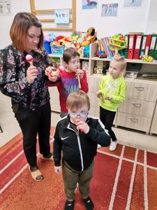 Na zdjęciu Pani Basia i dzieci. Wszyscy stoją i grają na instrumentach.