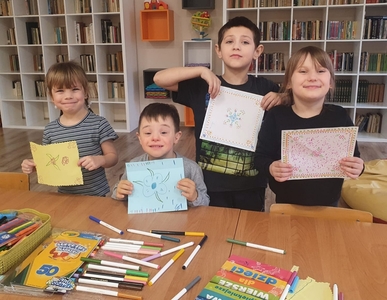 Przedszkolaki z uśmiechem prezentują swoje prace. Chusteczki są kolorowe i pomysłowe.