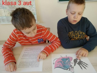 Hubert i Krystian czytają „Legenda o Czarciej Łapie” i wykonują pracę plastyczną. 