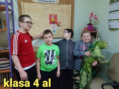Klasa 4 al. Uczniowie umieszczają obrazek z herbem Krakowa, nazwą miasta i tytułem legendy - „Legenda o smoku  wawelskim” na mapę Polski. Wiktoria trzyma pluszowego smoka.