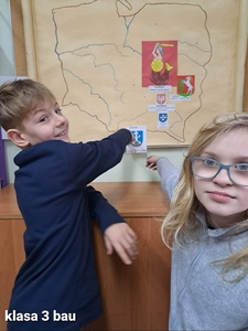 Klasa 3 bau. Madzia, Kacper i Wiktor umieszczają obrazek z herbem Zakopanego, nazwą. miasta i tytułem legendy – „Śpiący rycerz w Tatrach” na mapę Polski.