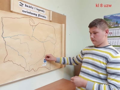 Paweł przyczepia obrazek z herbem Rzeszowa, nazwą miasta i tytułem legendy „Legenda o smoku rzeszowskim” na mapę Polski.