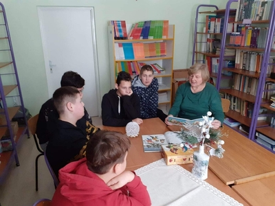 Na zdjęciu Pani bibliotekarka czyta chłopcom "Opowieść wigilijną".