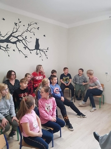 Na zdjęciu uczniowie i nauczyciele. Słuchają czytanej baśni "Dziewczynka z zapałkami".