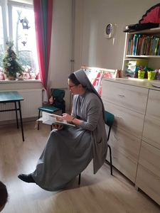 Siostra Agata czyta dzieciom baśń. 