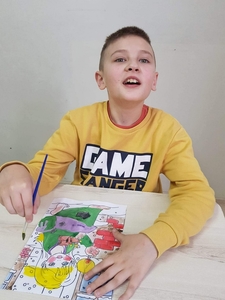 Gabryś, uczeń klasy 2 az  maluje farbami obrazek przedstawiający " dziewczynkę z zapałkami".