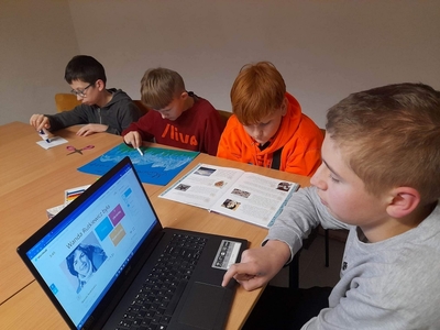 Alan wykonuje ćwiczenie interaktywne, Jakub maluje plakat, Michał czyta ciekawostki a Franek smaruje klejem obrazek. 