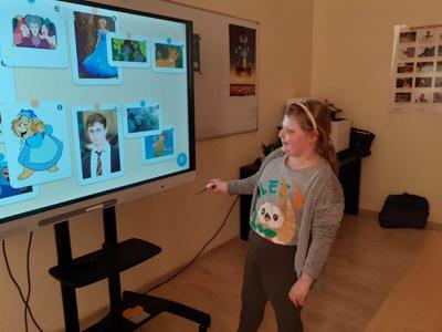 Uśmiechnięta Wiktoria podchodzi do tablicy i dopasowuje obrazki. 