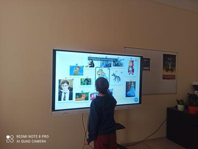 Adaś dopasowuje obrazki na tablicy interaktywne