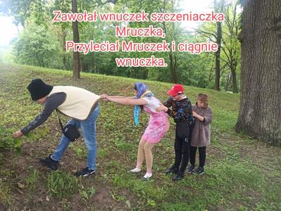 Na zdjęciu dzieci przebrane w stroje. Do nich dołącza Dawid, piesek Mruczek. 