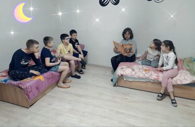 Na zdjęciu Pani Aneta czyta dzieciom bajkę do snu. 