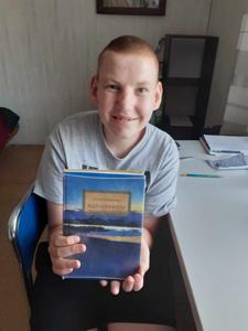 Na zdjęciu uczeń Łukasz prezentuje książkę "Nad Niemnem", Elizy Orzeszkowej. 