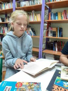 Ola czyta głośno powieść M. Konopnickiej. 