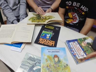 Pani bibliotekarka czyta dzieciom książkę autorki M. Konopnickiej. 