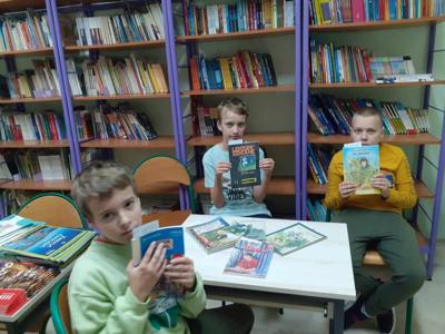 Krystian, Piotr i Hubert prezentują pierwsze książki wypożyczone w tym roku szkolnym.