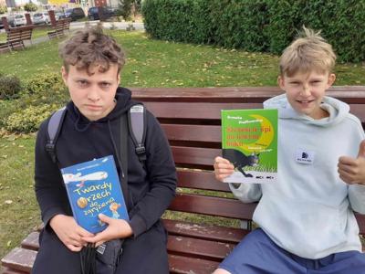 Przemek i Jakub prezentują swoje pierwsze książki wypożyczone w tym roku szkolnym. 