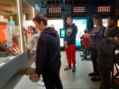 Uczniowie zwiedzają eksponaty w muzeum.