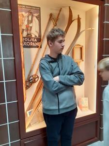 Alan przed gablotą z eksponatamu sportowymi.
