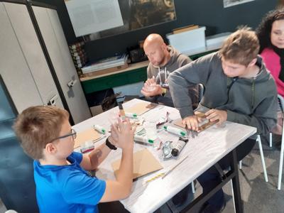 Alan i Dawid modelują i ugniatają glinę.