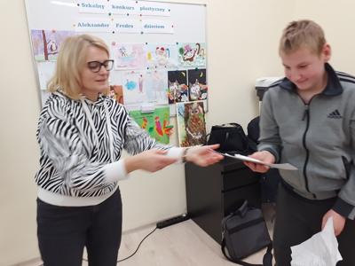 Pani Ania Sz. wręcza dyplom Łukaszowi.