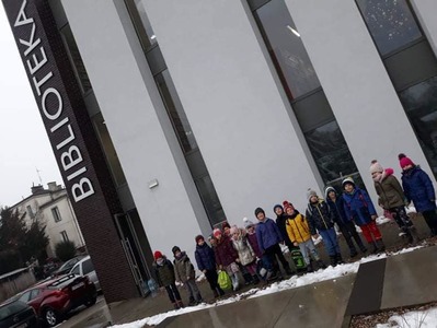 Dzieci z klasy 0 przed budynkiem Miejskiej i Powiatowej Biblioteki Publicznej w NDM
