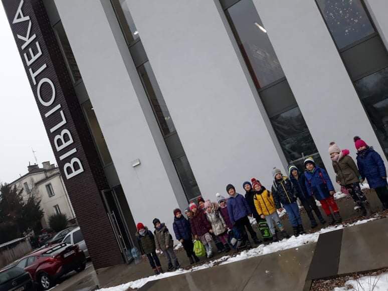 Dzieci z klasy 0 przed budynkiem Miejskiej i Powiatowej Biblioteki Publicznej w NDM