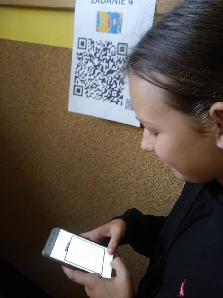 Ósmoklasistka rozwiązująca jedną z zagadek językowych z wykorzystaniem swojego smartfona