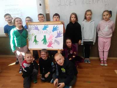 

Uśmiechnięci uczniowie na tle klasy prezentują wspólnie stworzony plakat.



Uśmiechnięci uczniowie na tle klasy prezentują wspólnie stworzony plakat.

