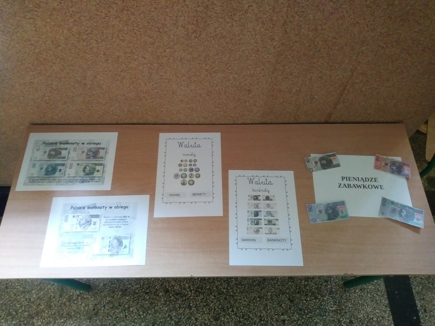 Na pierwszym tle wystawa zawierająca informacje czym są banknoty oraz monety.