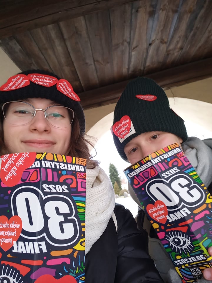 Uśmiechnięte uczennice z puszkami WOŚP.