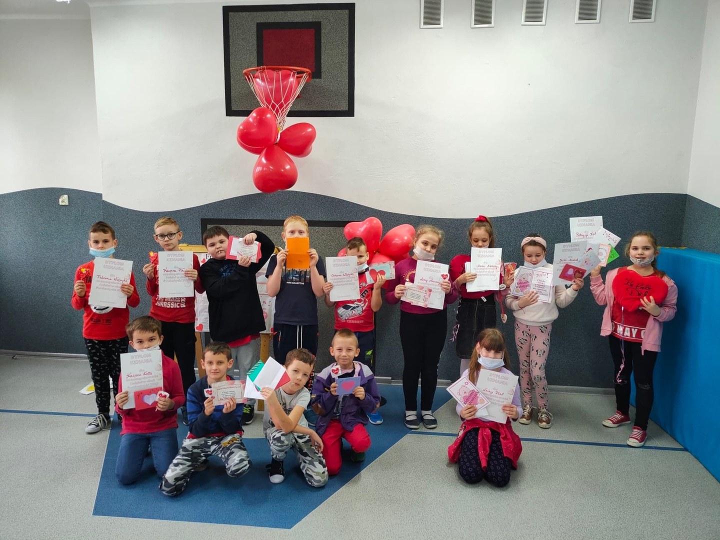 Uczniowie prezentujący dyplomy i upominki w ramach obchodów tegorocznych Walentynek.