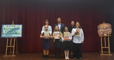 Zdjęcie przedstawia 4 uczennice z naszej szkoły, biorące udział w konkursie: ( od lewej strony) Lenę Nawarę, Patrycję Kot, Julię Nowak i Marię Szawińską. Za uczennicami stoją jurorzy.