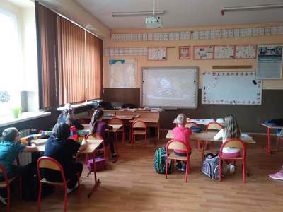 Zdjęcie przedstawia dzieci uczęszczające na zajęcia świetlicowe, podczas oglądania filmiku edukacyjnego.
