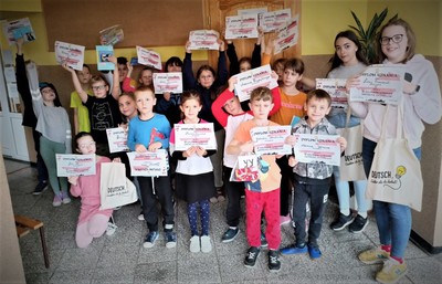 Nagrodzeni uczniowie prezentujący dyplomy i upominki.