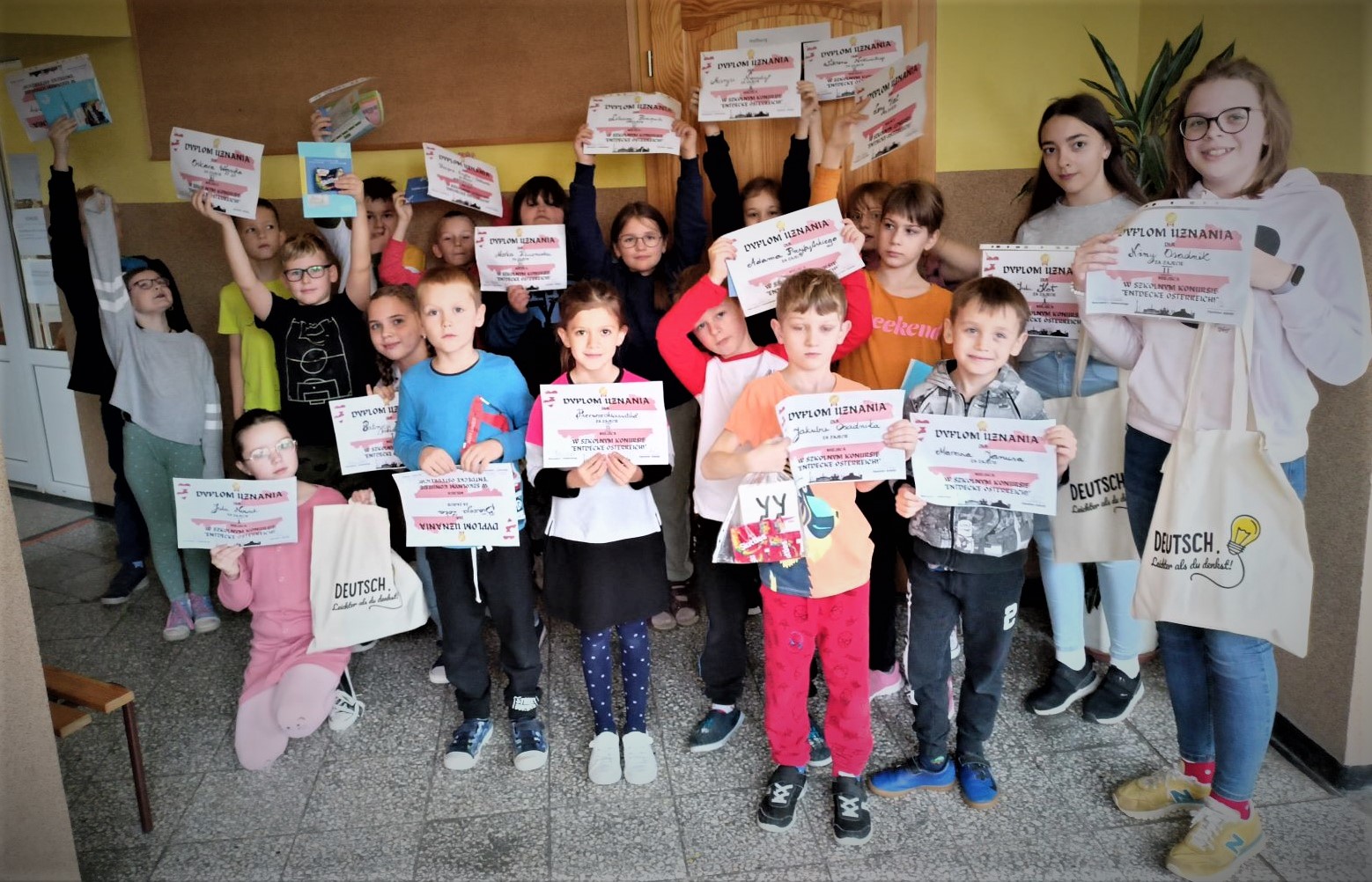 Nagrodzeni uczniowie prezentujący dyplomy i upominki.