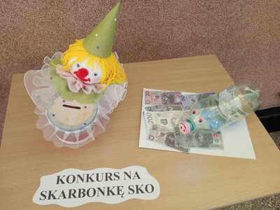 Wystawa skarbonek SKO na szkolnym korytarzu.