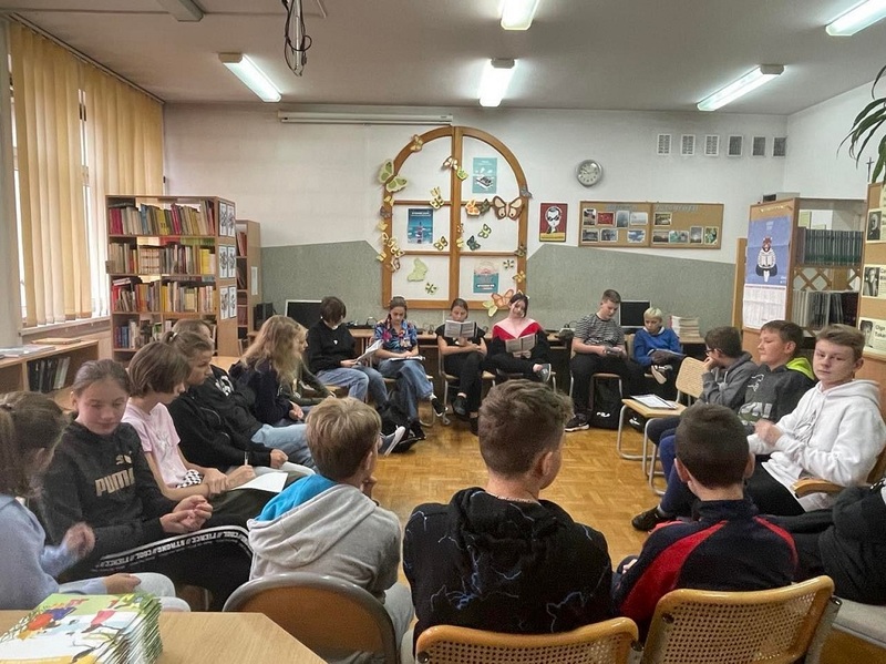 Uczniowie klasy 7 (Marysia, Ania, Nikola, Ola, Igor i Oskar) podczas głośnego czytania fragmentu książki Małgorzaty Musierowicz „Ida sierpniowa”. 