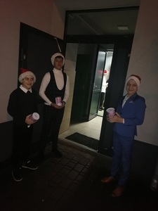 Chłopcy w mikołajowych czapkach zachęcają do wrzucania pieniędzy