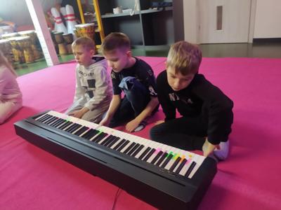 chłopcy grający na instrumencie klawiszowym