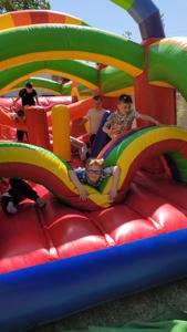 uczniowie bawią się na dmuchanej zjeżdżalni