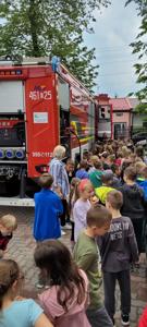 pokazy strażackie, grupa dzieci ze strażakiem