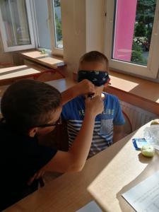 Chłopiec podaje koledze na łyżeczce cynamon.