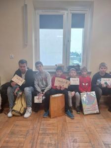 uczniowie reprezentujący szkołę w konkursie szachowym z dyplomami i nagrodami