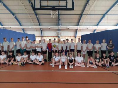 Uczniowie klas 5 pozujący do zdjęcia w hali sportowej