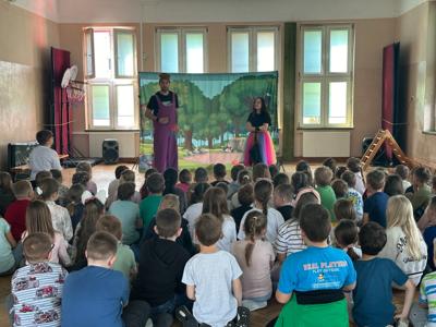 uczniowie w auli szkolnej oglądają przedstawienie