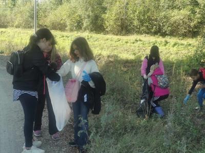 Uczennice  3d zbierające śmieci na poboczu leśnej drogi