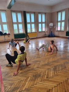uczniowie grają w piłkę w podporze tyłem w sali gimnastycznej