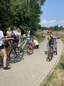 Grupa uczniów stoi przy rowerach.
