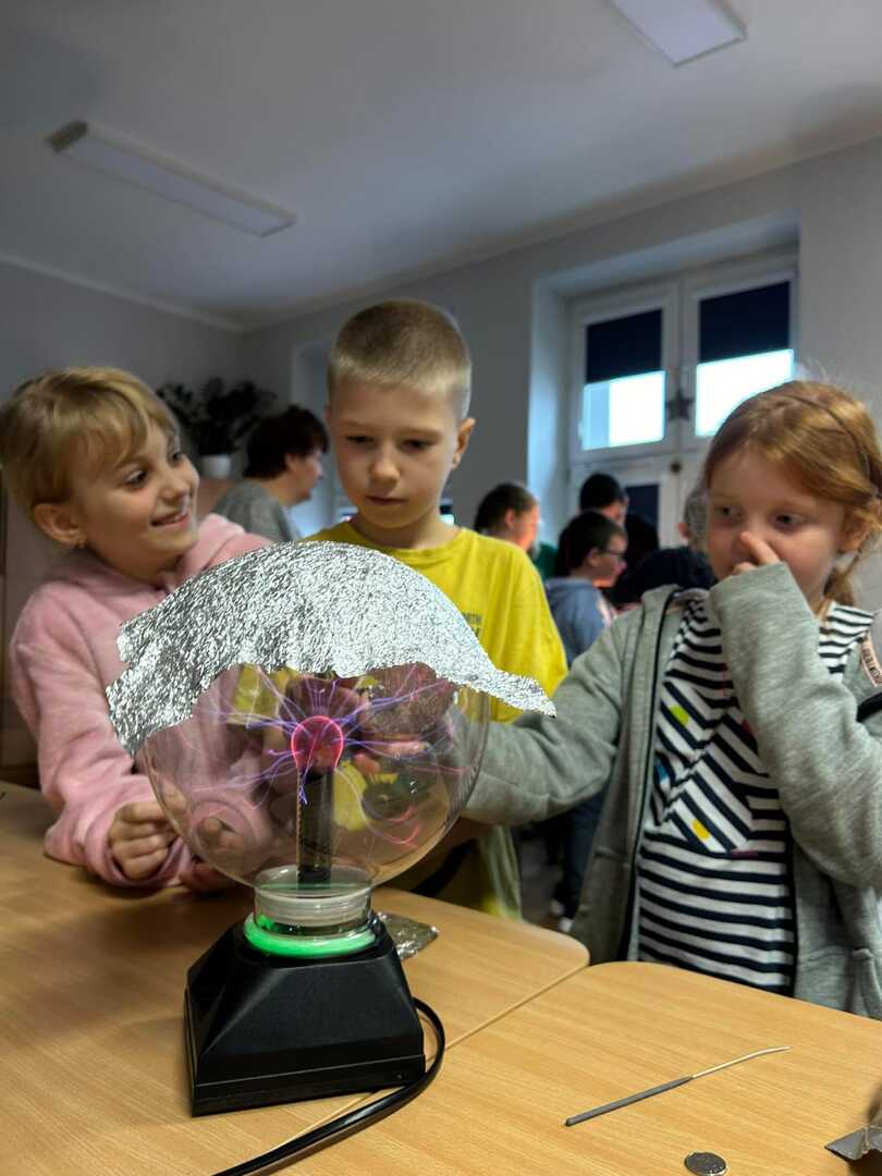 Uczniowie z klasy 2a obserwują efekt działania lampy plazmowej.